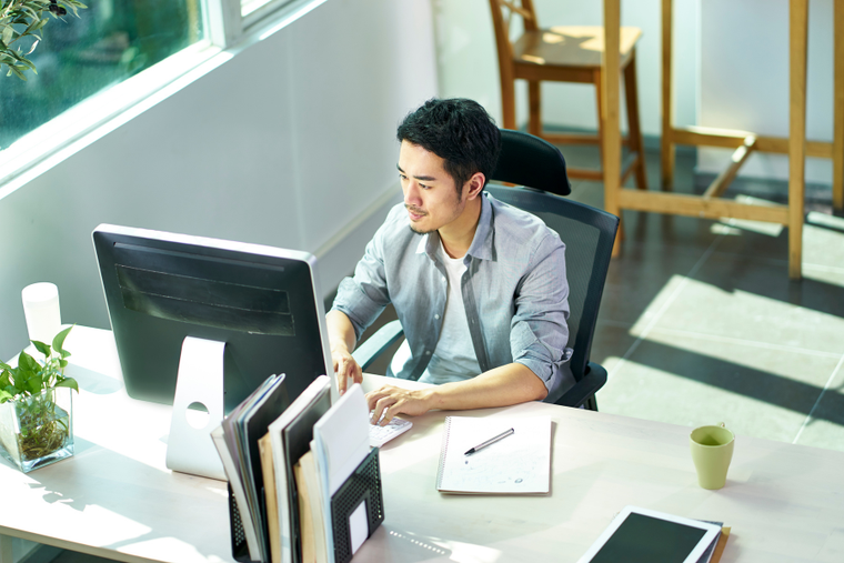 a gentleman sits at a computer working