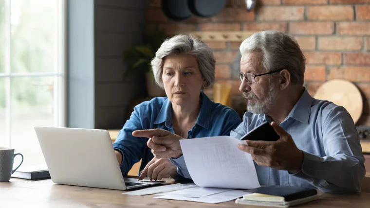 A couple sit in front of their laptop evaluating charities