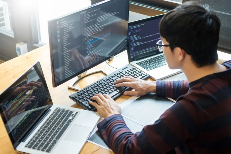 A web developer working with code on his desktop computer