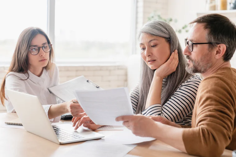 A couple looking over paperwork with a consultant/advisor