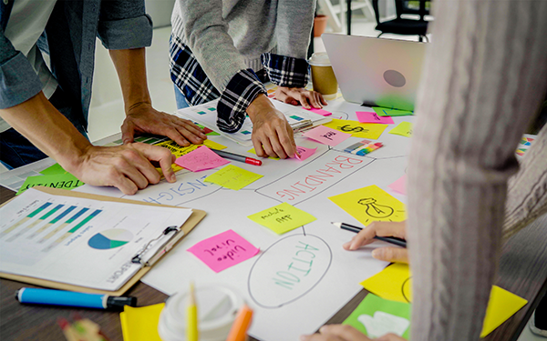 A group of nonprofit employees stand at a table working on their giving strategy plan