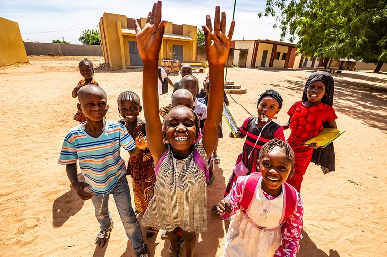 A group of children smile and laugh