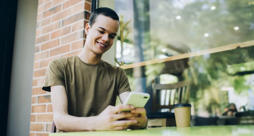 Young person smiling at their phone