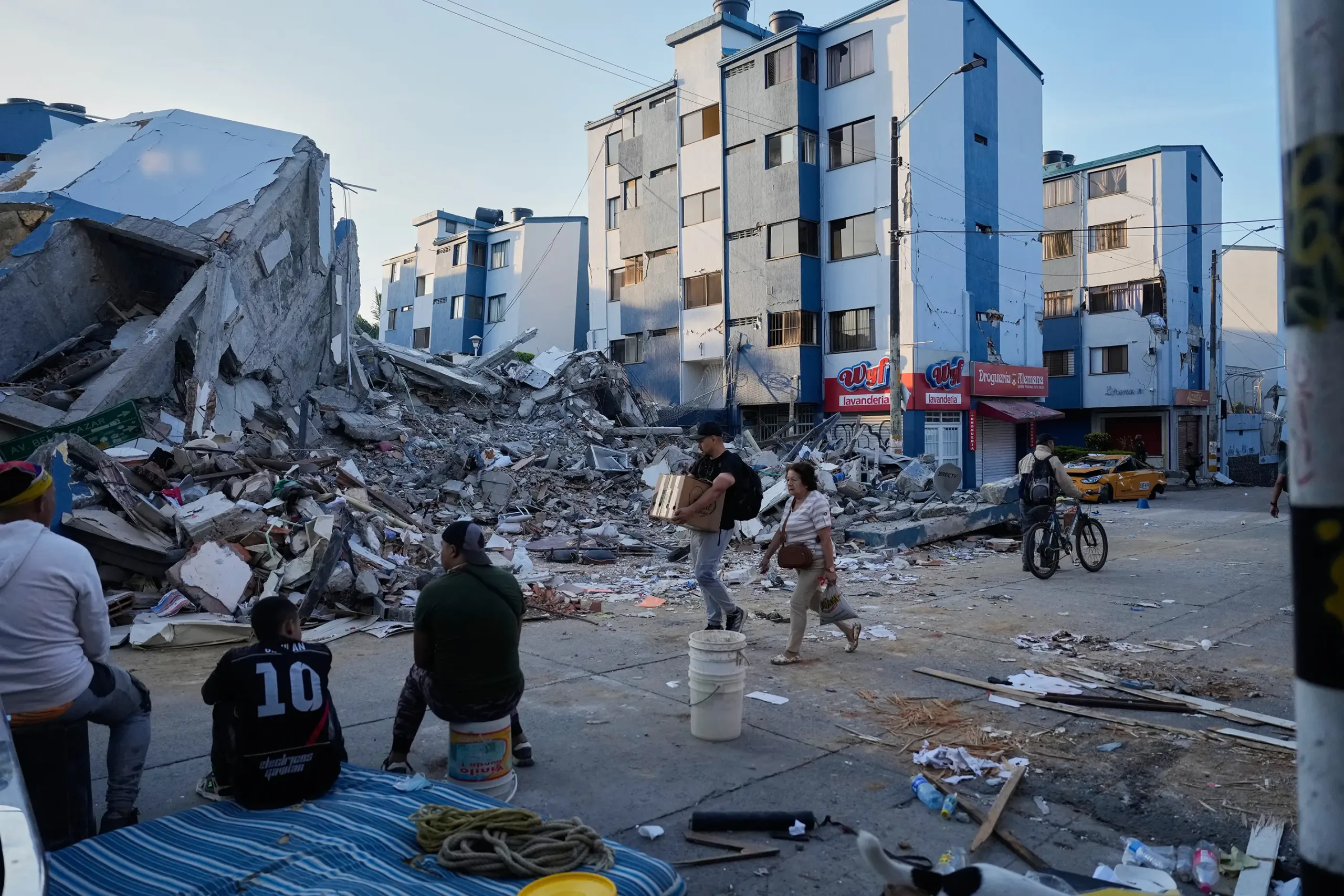 Wide shot of destroyed buildings and people walking by in Colombia, after the earthquake